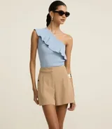 Short color beige de cintura alta, confeccionado en tejido plano con estructura sastre, con bolsillos laterales con tachuelas metalizadas.