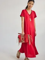 Vestido largo rojo de tejido de punto, con cuello en V y mangas cortas. Presenta costuras verticales a lo largo del vestido.