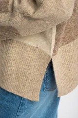 Sweater de punto color beige con mangas largas combinadas en tonos de marrón.