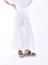 Pantalón blanco de corte cropped y ruedo acampanado con volantes.