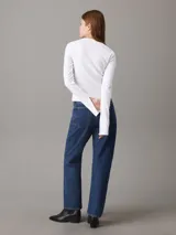 Top blanco de algodón con textura de canalé, corte slim, cuello redondo y mangas largas con puños con abertura.