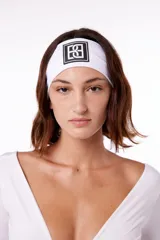 Vincha deportiva blanca de poliéster con logo negro estampado en el centro.