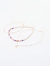 Set de tres collares dorados de diferentes largos. Uno es una cadena de eslabones, otro es una cadena de bolitas doradas y el tercero es una cadena fina con bolitas y un dije redondo con una inscripción.