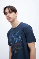 Remera negra de algodón con estampa central con la frase "Life Rhythm Punches Awakes" y pequeño logo en la espalda.