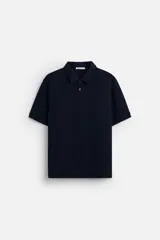 Polo azul marino de corte regular, con cuello solapa y cierre frontal de botonadura.