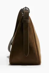 Cartera marrón de gamuza sintética con correa de hombro ajustable y cierre superior con cremallera.