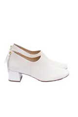 Zapato de cuero color blanco hueso, con punta cuadrada, suela laqueada antideslizante, cierre trasero y taco forrado de 5 cm.