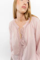 Blusa rosa de algodón con escote en V con cordones y detalle de volados.