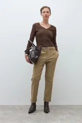 Pantalón de vestir color caqui, corte recto y tiro alto, con elástico en la cintura y cinto fino con hebilla metálica redonda.