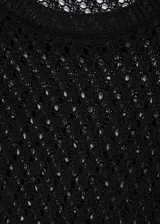Clutch de mano confeccionado en rafia natural trenzada, con detalles en cuero negro en los bordes y en las asas.