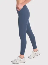 Calza deportiva color beige, tiro alto, con bolsillos laterales y banda de silicona en la cintura.