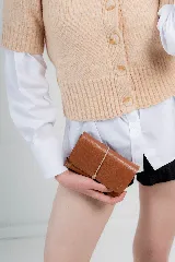 Billetera tipo sobre de cuero negro con cierre de elástico, separaciones internas y bolsillo con cierre para monedas.