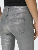 Pantalón jean skinny color gris metalizado, con cierre de cremallera y trabillas para cinturón.