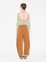 Pantalón color marrón confeccionado en poplin 4way. Incluye bolsillos laterales y ojales en la parte trasera, con presillas en la cintura para ajuste. Acceso mediante cierre, gancho pantalonero y botón interno.