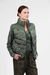 Chaleco verde militar con estampado de paisajes en negro, cuello alto y cierre frontal.