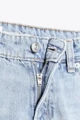 Pantalón de jean celeste de corte recto y tiro bajo, con cinco bolsillos y cierre frontal con cremallera y botón metálico.