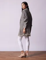 Camisa de jean celeste, marca Hester & Orchand, de corte oversize con cuello con solapa, escote en V y abertura central con botones. Delantera con bolsillos aplicados, mangas largas regulables con presilla y botón, y ruedo desflecado.