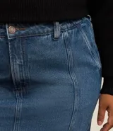 Pollera midi de jeans azul, corte sirena, con cintura elástica, trabillas, bolsillos laterales y recortes verticales.