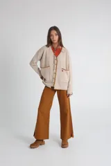 Saco cardigan beige de tejido de punto acanalado con cuello en V, cierre frontal con botones marrones, bolsillos de parche y ribete marrón en cuello, bolsillos y puños.