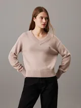 Sweater de punto color rosa pálido con cuello en V y logo bordado en el pecho.