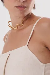 Collar dorado con diseño de ondas, que agrega un toque elegante a cualquier atuendo.