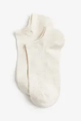 Pack de soquetes blancos de algodón con borde superior elástico y tejido de punto fino acanalado.