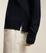 Suéter negro de punto con cuello redondo y mangas largas.