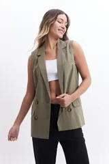 Chaleco color verde oliva estilo blazer, con solapa clásica, doble botonadura y bolsillos delanteros. Sin mangas.