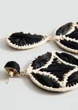 Par de aros colgantes con forma circular y gota, hechos de fibra natural tejida en color negro y crudo.