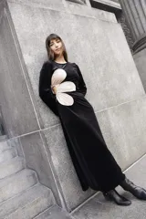 Vestido largo de terciopelo negro con paneles laterales en color crema y abertura en la espalda.
