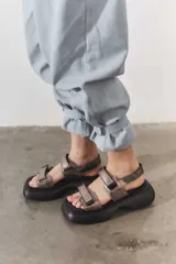 Sandalias negras con plataforma, tiras anchas con ajuste de velcro y detalle plateado en el talón.