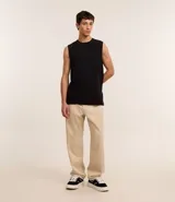 Pantalón baggy negro de sarga de algodón, con cintura fija con trabillas, botón contrastante y cierre por cremallera oculto, bolsillos laterales y traseros. Modelo holgado de corte recto y ancho.