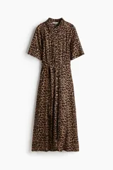 Vestido midi con estampado de leopardo, cuello camisero, manga corta y botonadura frontal. Presenta elástico en la cintura y cinturón extraíble para atar.