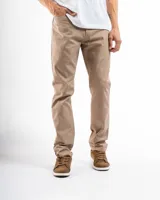 Pantalón de gabardina color beige, de corte recto, con bolsillos laterales y traseros. Se ajusta a la cintura con cinturón de cuero marrón.
