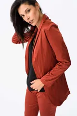 Blazer color bordó de satén elastizado, con corte entallado, terminaciones cuidadas, bolsillos discretos y cierre frontal de un botón.