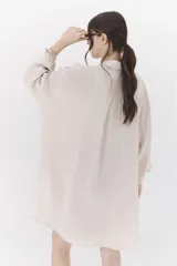 Camisa color beige de lino, de corte amplio, con cuello clásico y mangas 3/4.