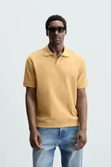 Polo azul marino de punto con textura acanalada vertical, corte regular fit, cuello solapa con abertura frontal y mangas cortas.