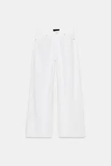 Jeans blancos de tiro medio con cinco bolsillos y pernera ancha. Cierre frontal con botones.