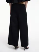 Pantalón ancho color marrón, con pretina con botón metálico y pasacinto. Incluye cinto fino de cuerina negra.
