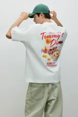 Remera blanca de corte oversized con estampado rojo de la leyenda "Tommy's Diner" en el pecho.