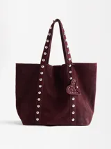 Bolso tote de gamuza color marrón con tachas plateadas en las tiras y los laterales.