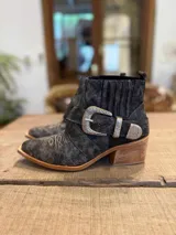Botinetas texanas de cuero gastado color gris, con bordados blancos en la puntera y caña, hebilla decorativa plateada y taco de madera.