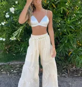 Pantalón beige de corte palazzo, con cintura elástica y diseño escalonado.