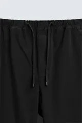 Pantalón verde militar de corte carrot fit, confeccionado en tejido de algodón. Cuenta con cintura elástica ajustable con cordón, bolsillos frontales y un bolsillo trasero de plastrón.