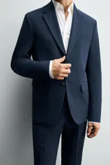 Blazer slim fit azul marino confeccionado en tejido con viscosa. Cuello con solapas de muesca, manga larga con puño abotonado, bolsillo de vivo en pecho y de solapa en cadera, bolsillo interior, bajo con aberturas en espalda y cierre frontal con botones.