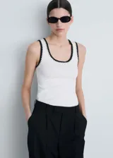 Musculosa blanca de algodón con cuello redondo y ribete negro.