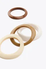 Pack de cuatro pulseras de resina de diferentes tamaños en tonos marrón, beige y blanco.