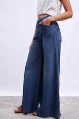 Pantalón de jean azul oscuro, modelo wide leg (pierna ancha) con tiro alto y cierre frontal de botones.