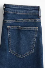 Pantalón de jean acampanado de tiro bajo, color azul oscuro.