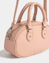 Cartera bowling color rosa viejo de cuerina con correa regulable desmontable, manijas superiores, doble cierre superior y tag de metal.